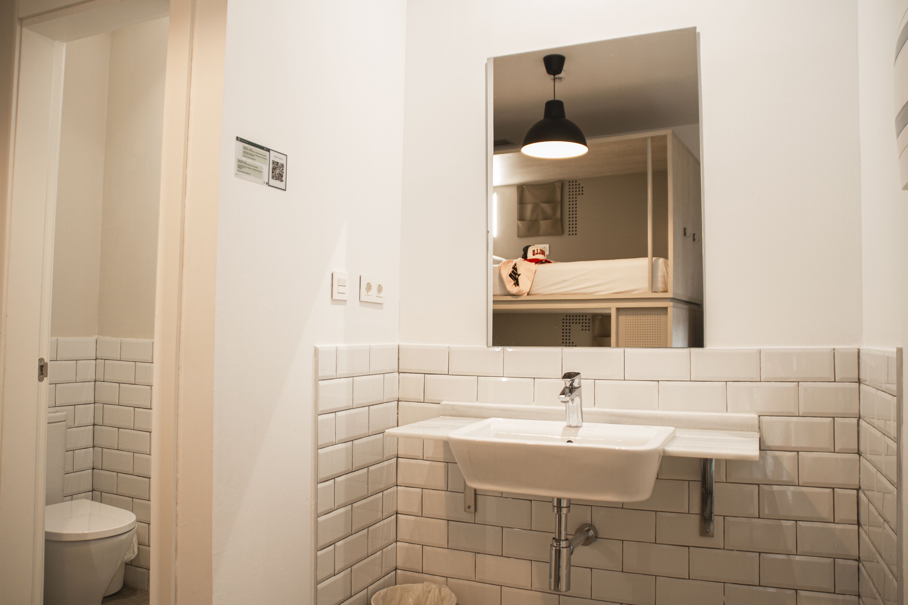 A bathroom with a white sink, a mirror, and a toilet.
