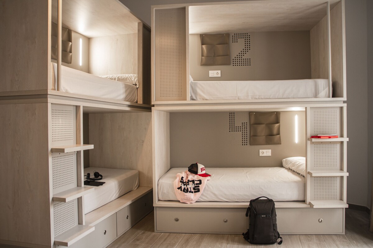 A multi-level bunk bed room with storage drawers and shelves.