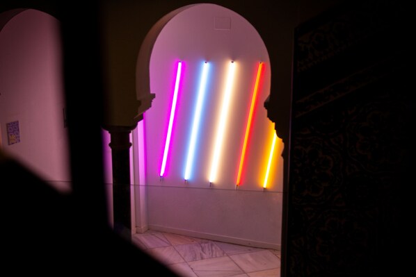 A hallway with a series of illuminated vertical bars in various colors.
