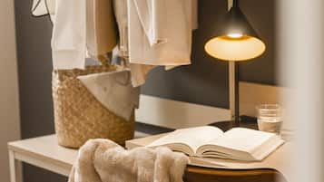 A neatly arranged reading area with a book, a lamp, and a glass of water on a table.