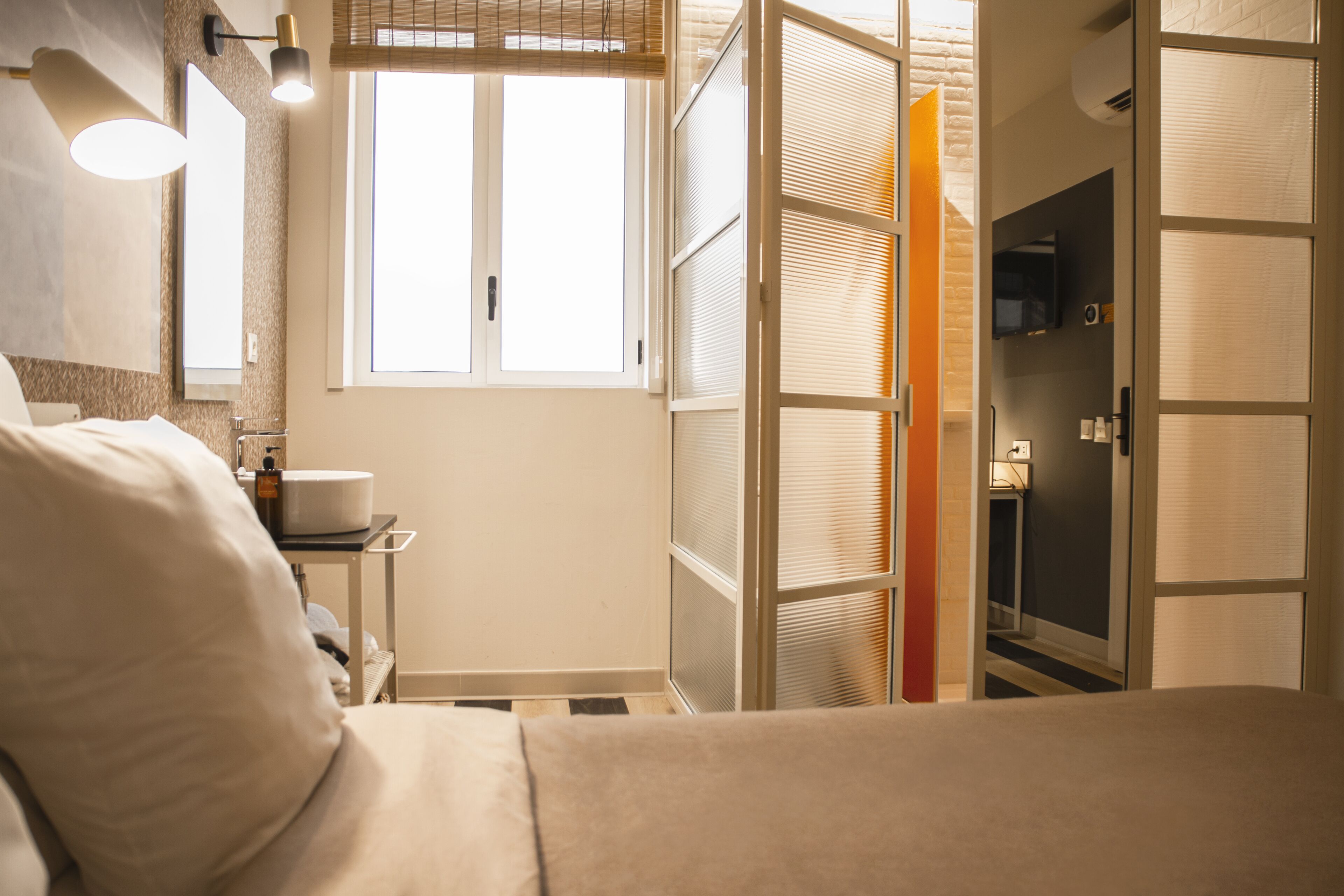 Una habitación de hotel con una cama, una mesita de noche, una ventana y un armario.