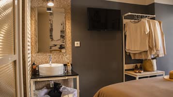 Un baño moderno con un espejo grande, lavamanos y toallero.