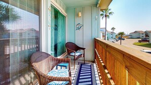 Ein Balkon mit Korbstühlen und einer blau-weiß gestreiften Matte.