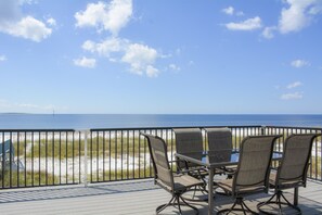 A deck with outdoor seating overlooking a beach and ocean. - Herring House- Gulf front, St Joe Beach, WIFI, No pets, Sleeps 7 (Saint Joe Beach)