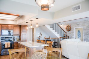A modern kitchen with wooden cabinets, a central island, and pendant lighting. - Herring House- Gulf front, St Joe Beach, WIFI, No pets, Sleeps 7 (Saint Joe Beach)