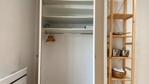 A walk-in closet with open shelving, a wooden floor, and a white wall. - Le Cocon / Hyper-Centre / Air-conditioning / Trams (Grenoble)