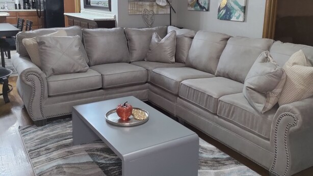 Un salon avec un canapé d’angle, une table basse et un tapis.