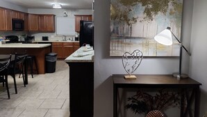 Une cuisine moderne avec des meubles en bois, un îlot central et un coin repas avec des chaises.