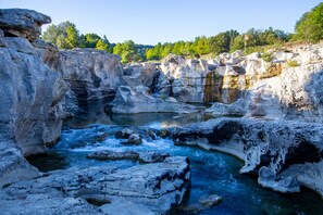 Una formazione rocciosa naturale con un fiume che scorre al suo interno.