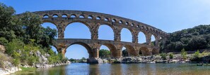 Un ponte ad arco in pietra che scavalca un fiume, immerso nel verde.
