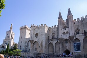 Un castello storico con una torre imponente e finestre ad arco.