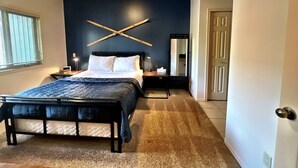 A bedroom with a bed, bedside tables, a mirror, and a door. - Willow Vistas 6 - Golf - Ski - Hike - Chill - Private Hot Tub - Sleeps 6 (Kimberley)