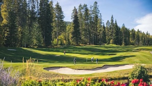 A golf course with sand bunkers, a pond, and a forest in the background. - Willow Vistas 6 - Golf - Ski - Hike - Chill - Private Hot Tub - Sleeps 6 (Kimberley)
