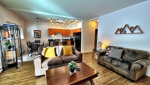A modern living room with a sofa, a coffee table, and a dining area. - Willow Vistas 6 - Golf - Ski - Hike - Chill - Private Hot Tub - Sleeps 6 (Kimberley)