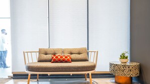 A modern living room with a sofa, a patterned side table, and a potted plant. - Go Hotels Plus Naga (Naga)