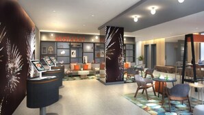 A modern hotel lobby with seating areas, a reception desk, and a large wall with a 'MUSTA' sign. - Go Hotels Plus Naga (Naga)