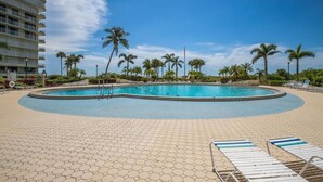 A pool area with a circular pool, palm trees, and lounge chairs. - Beachfront 2BR/2BA South Seas condo with pool, WiFi, and full kitchen. (Marco Island)