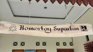 A wooden sign with the text "Homestay Suparlan" hanging from the ceiling. - Borobudur Kampung Homestay - Suparlan (Magelang)