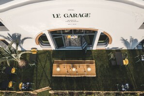 Das Hotel Le Garage, mit moderner Architektur, einem Dachterrasse-Bar und einer Außenbereich-Sitzgelegenheit.