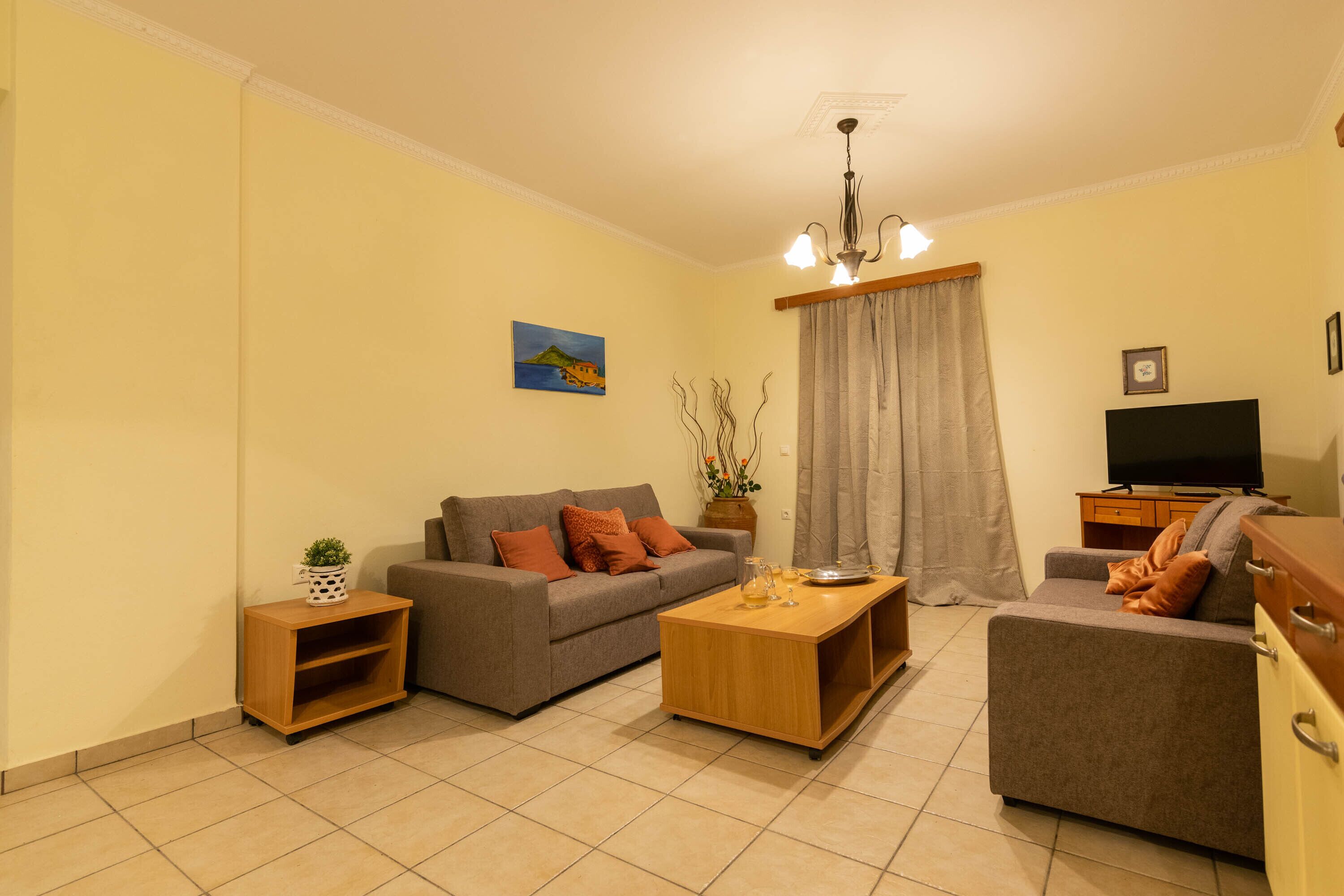 A living room with a sofa, a coffee table, a TV, and a cabinet.