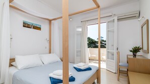 Quarto com cama de dossel, escrivaninha e cadeira.