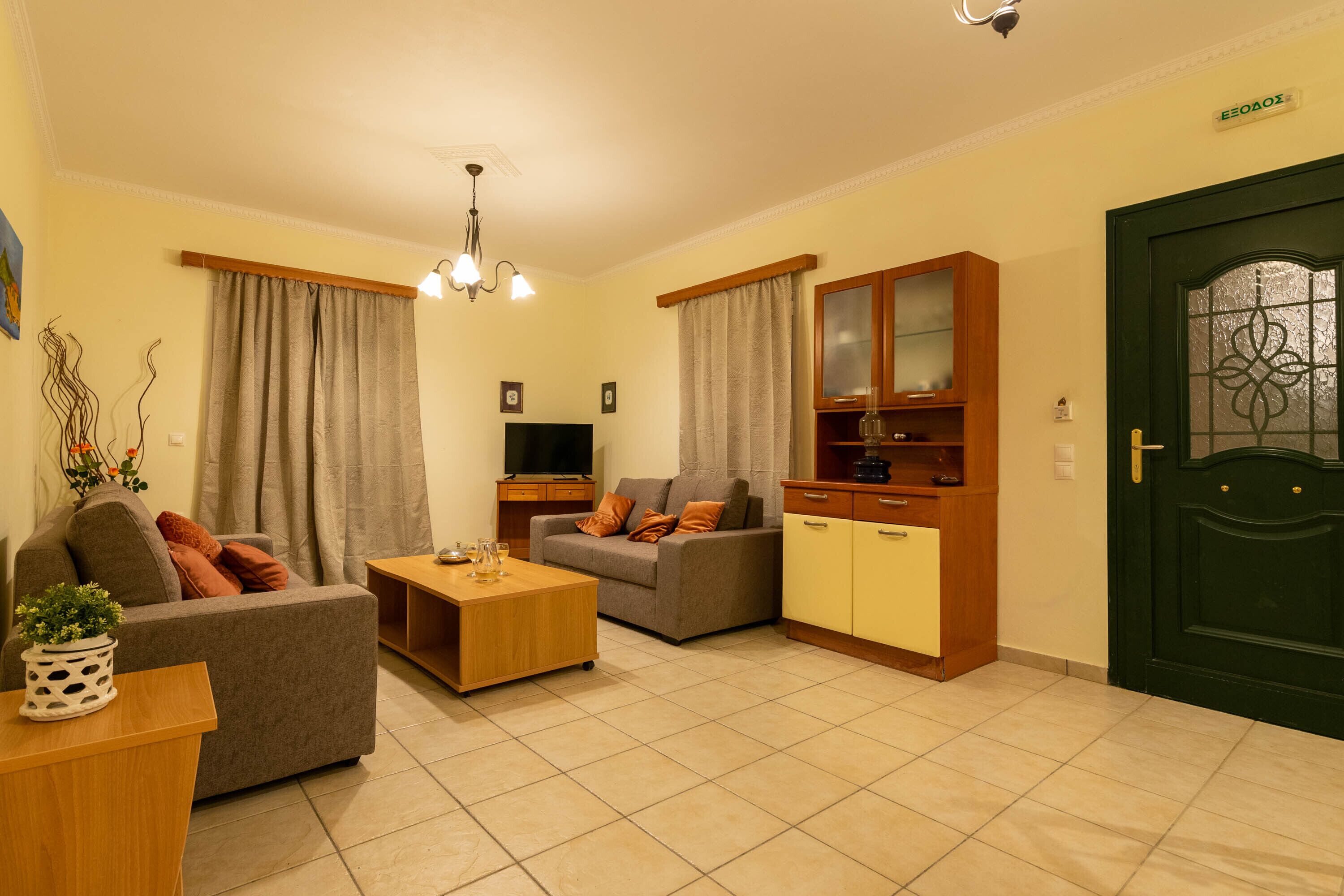 A living room with a sofa, a coffee table, a TV, and a cabinet.