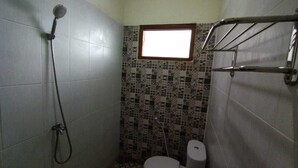 A small bathroom with a shower, toilet, and a window.