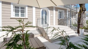 A modern house with a covered porch, a spiral staircase, and a small garden area. - Villa Levante (Lido di Camaiore)