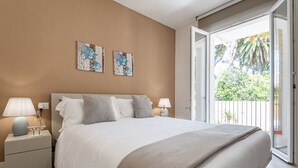 A bedroom with a large bed, two bedside tables with lamps, and artwork on the wall. - Villa Levante (Lido di Camaiore)