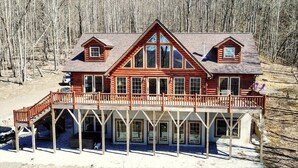 A large log cabin with a prominent front porch and multiple windows. - Escape to Daltons Creek Cabin in Creston, NC, perfect for family fun! (Creston)