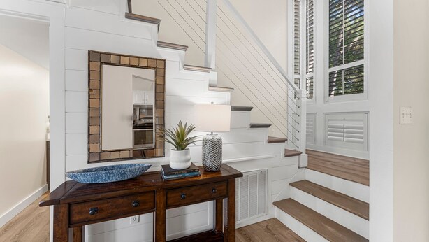 A staircase with white railings and wooden steps leading to a landing.