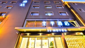A hotel with a modern facade, illuminated signage, and a prominent entrance. - Ji Hotel (Shanghai)
