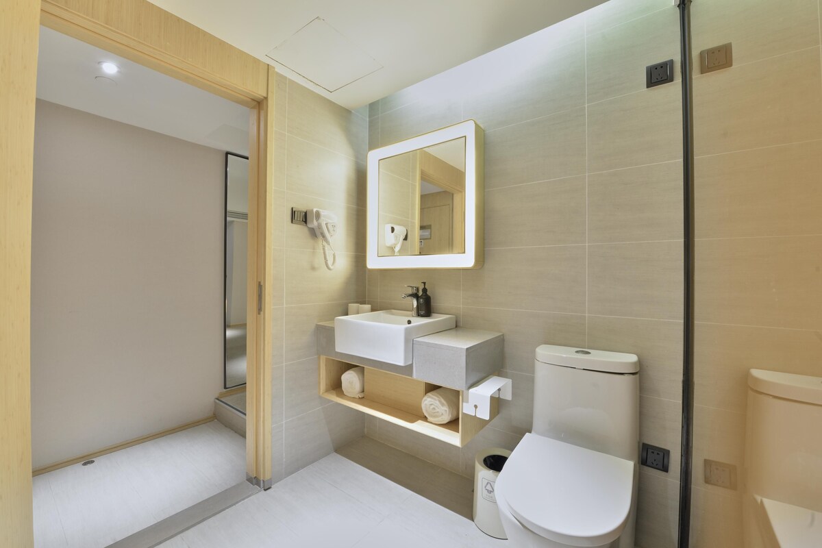A modern bathroom with a toilet, sink, and shower area.