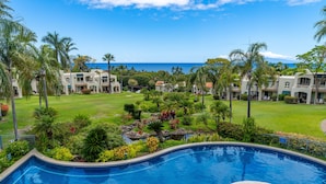 Ein Resort mit Schwimmbad, üppiger Vegetation und Blick auf den Ozean.