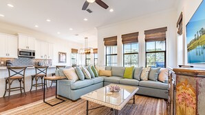 A modern kitchen with white cabinets, a stainless steel microwave, and a brick backsplash. - Golf Carts ~ Patio ~ Balcony ~ Community Pool (Miramar Beach)