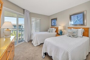 A hotel room with two beds, a dresser, a window with blinds, and artwork on the walls. - Spacious and Beachfront Condominium (Saint Simons Island)