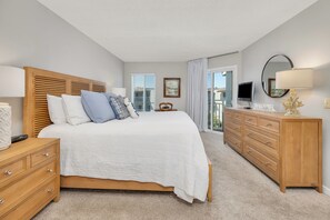 Relax in a spacious room with a large bed, wooden nightstand, and flat-screen TV.