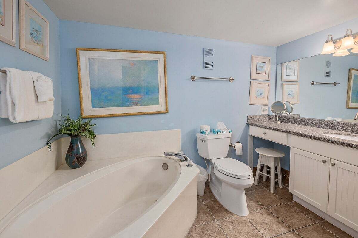 A bathroom with a bathtub, toilet, sink, and vanity.