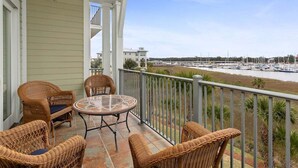 A balcony with wicker furniture and a view of a marina. - Breathtaking Views of the Inter-coastal Waterway (Saint Simons Island)