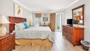 Un dormitorio con una cama grande, cómoda de madera y televisor.