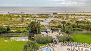 Een resort met een zwembad, ligbedden en uitzicht op het strand en de oceaan.