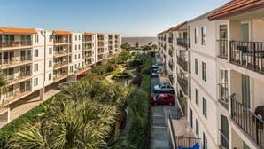 Ein mehrstöckiges Hotel mit Balkonen, einem Pool und Blick auf das Meer.