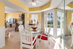 Relax in this open-plan living space with a dining area, TV, and large window offering a view of the outside.