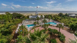 Ein Resort mit Pool, Palmen und Blick auf den Strand.