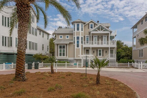 A two-story building with a balcony and a white picket fence.