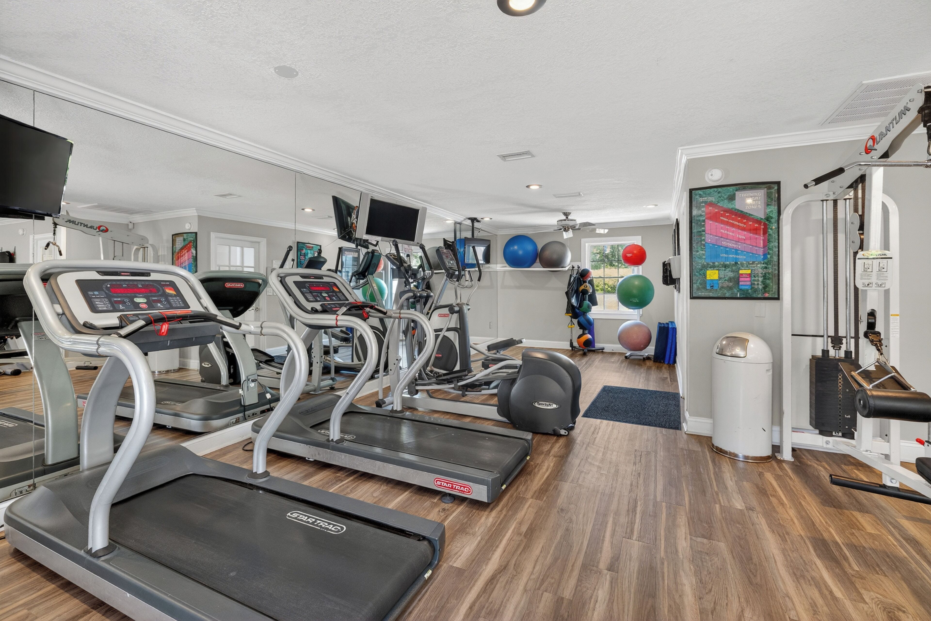 A gym with treadmills, elliptical machines, and various exercise equipment.
