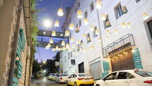 Une rue bordée de taxis en stationnement et un immeuble sur lequel on peut lire l’inscription « HÔTEL ».