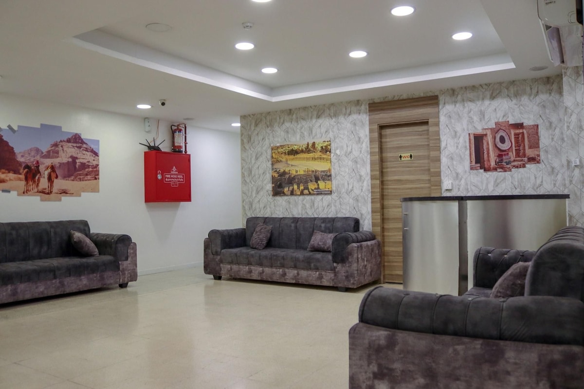 A lobby with two sofas, a fire hose reel, and a wall-mounted picture.