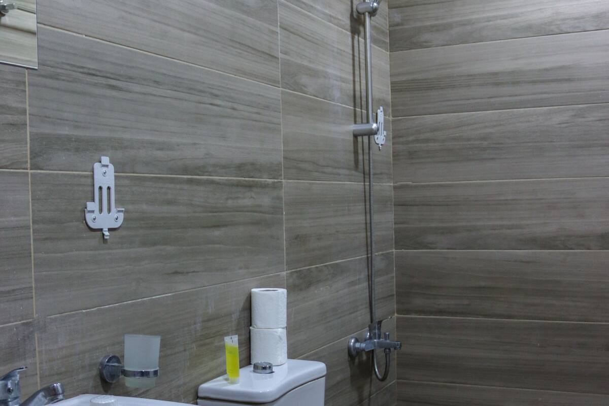 Un baño con lavamanos, inodoro y ducha.