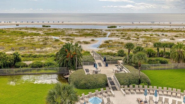 A resort with a pool area, lounge chairs, and a view of the beach and ocean. - Vacation on St Simons Island! Pool, Beach Access, Fitness Center, Tennis! (Saint Simons Island)